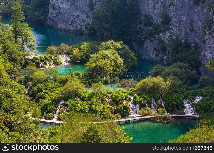 Cascade limpid lakes with waterfalls and planked footway across the lake in Plitvice Lakes National Park (Croatia)