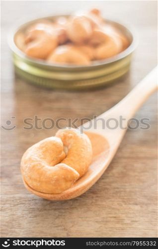 Cashew nut roast salt on weathered wooden table, stock photo