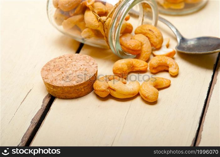 cashew nuts on a glass jar over white rustic wood table