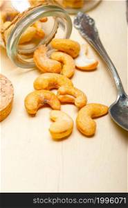 cashew nuts on a glass jar over white rustic wood table
