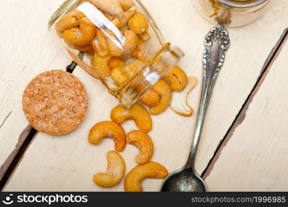 cashew nuts on a glass jar over white rustic wood table