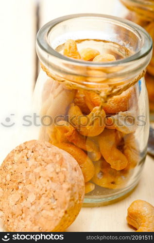 cashew nuts on a glass jar over white rustic wood table