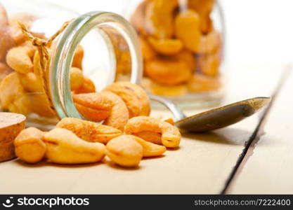 cashew nuts on a glass jar over white rustic wood table