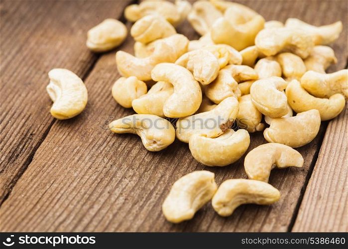 cashews scattered on the wooden table close up