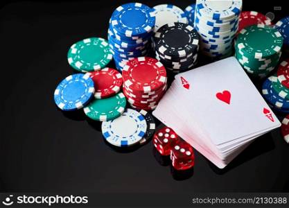 Casino chips, playing cards and dices on dark reflective background.. Casino chips, playing cards and dices on dark reflective background