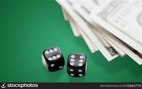 casino, gambling and fortune concept - close up of black dice and dollar cash money on green table background