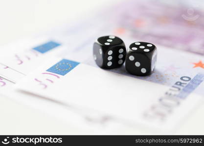 casino, gambling and fortune concept - close up of black dice and euro cash money