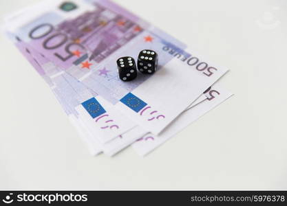 casino, gambling and fortune concept - close up of black dice and euro cash money