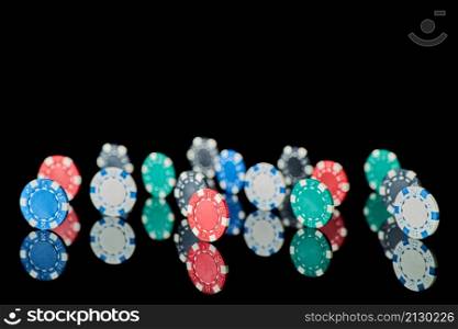 Casino gambling chips isolated on black reflective background.. Casino gambling chips isolated on black reflective background