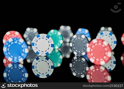 Casino gambling chips isolated on black reflective background.. Casino gambling chips isolated on black reflective background