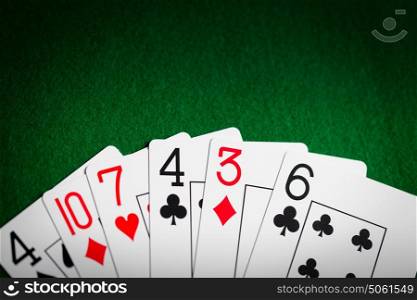 casino, gambling, games of chance, hazard and entertainment concept - poker hand of playing cards on green cloth. poker hand of playing cards on green casino cloth