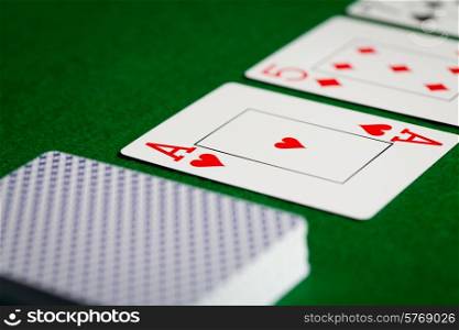 casino, gambling, poker, and entertainment concept - close up of playing cards on green table surface
