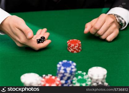 casino, gambling, poker, people and entertainment concept - close up of poker player with dice and chips at green casino table