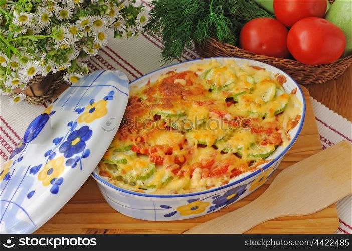 casserole of pasta with zucchini and tomato and cheese on the table