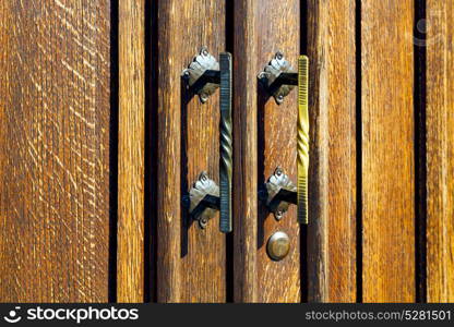 castellanza blur lombardy abstract rusty brass brown knocker in a door curch closed wood italy cross