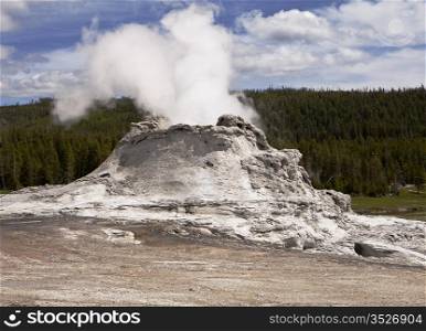 Castle Geyser is one of the larger volcanic geysers in Yellowstone National Park. With a large cone formed after years of eruptions, this viewpoint shows steam rising from the top vent.