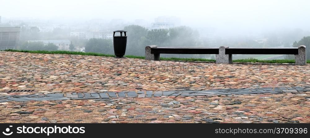Castle hill of Gediminas, sidewalk of boulders. Wastebasket and two wet bench.