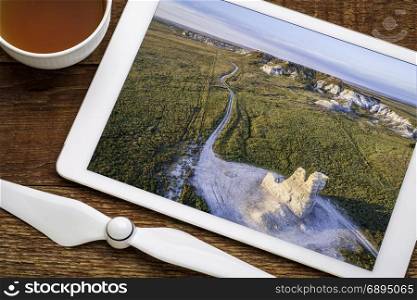 Castle Rock - limestone pillar landmark in prairie of western Kansas, reviewing aerial image on a digital tablet