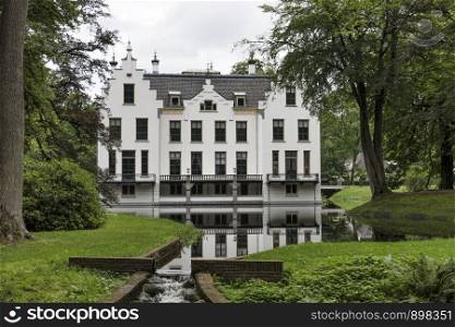 Castle Staverden reflecting in the moat and surrounded by nature trees and park. Castle Staverden reflecting in the moat and surrounded by trees