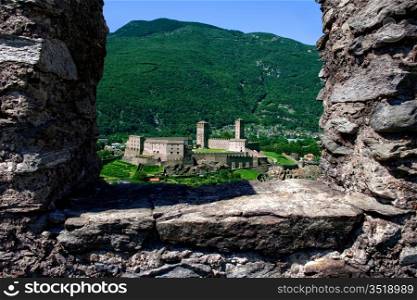 Castlegrande framed by ruined stone of Montebello Castle, Three Castles of Bellinzona, Ticino, Switzerland.