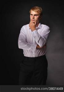 Casual and handsome modern businessman wearing black suit and white shirt, studio shot dark background