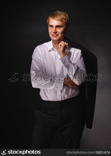 Casual and handsome modern businessman wearing black suit and white shirt, studio shot dark background