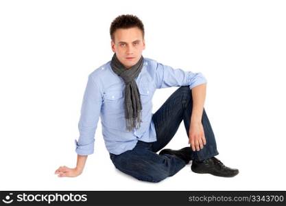 Casual attractive young man sitting on the ground, isolated on white background.