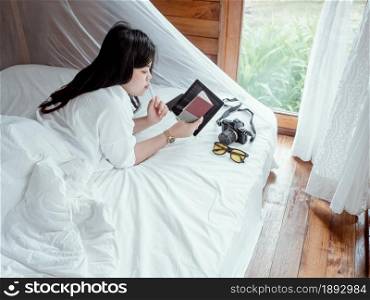 casual business concept from woman working with the tablet at bedroom on the bed.