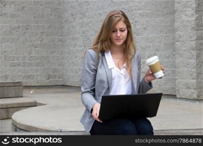 Casual business women works on laptop outside