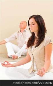 Casual business yoga young woman meditating with senior businessman colleague