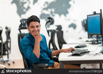 Casual businessman working on a desktop computer in modern open plan startup office interior. Selective focus. High-quality photo. Casual business man working on desktop computer in modern open plan startup office interior. Selective focus