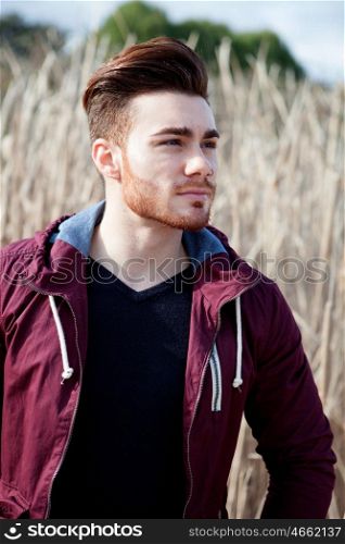 Casual cool young man with beard in the field