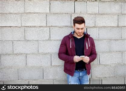 Casual cool young man with beard looking the mobile