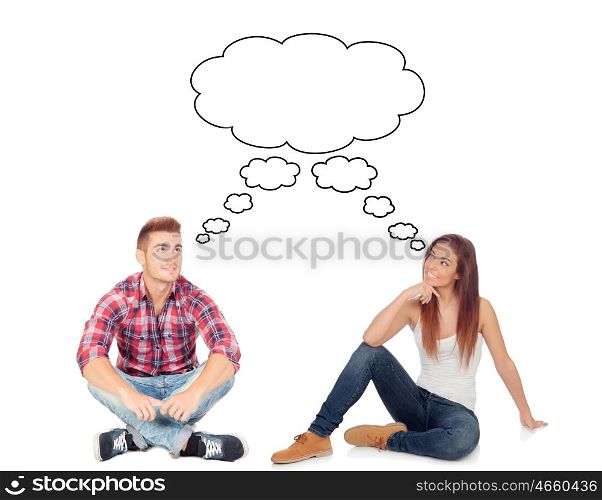 Casual couple sitting on the floor isolated on a white background