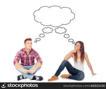 Casual couple sitting on the floor isolated on a white background