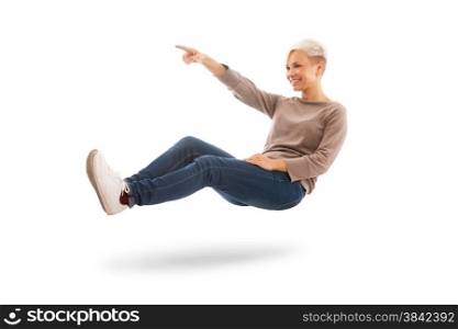 Casual dressed woman is floating while indicating a direction over white isolated background