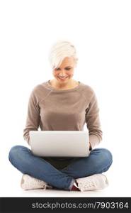 Casual dressed woman sitting on the floor with laptop over white isolated background