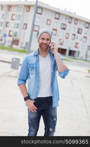 Casual fashion guy calling with his mobile in the city