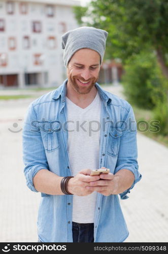 Casual fashion guy taking a walk with his mobile in the city