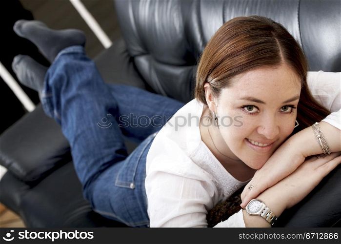 casual girl smiling and relaxing on a sofa at home