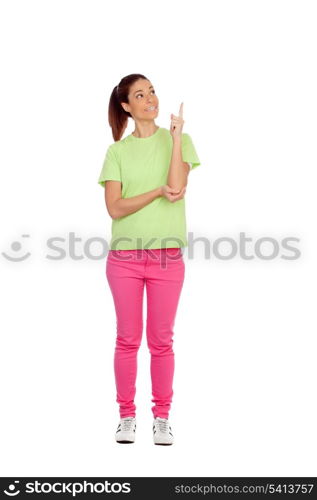 Casual girl with pink jeans indicating something with the finger isolated on a white background