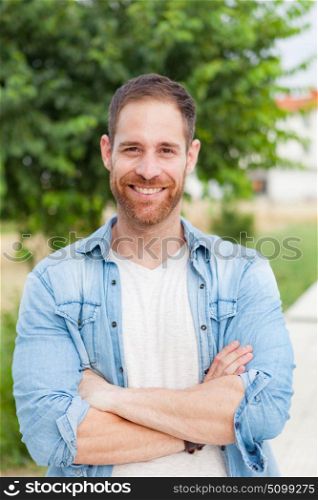 Casual guy with a denim shirt relaxed in a park