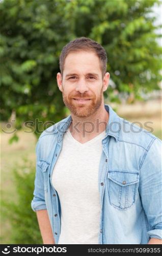 Casual guy with a denim shirt relaxed in a park