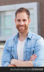 Casual guy with a denim shirt relaxed in the street