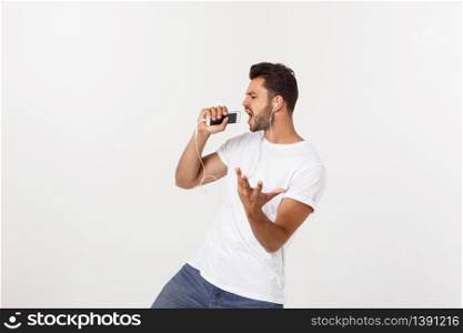 Casual handsome man dancing with mobile phone isolated on white background.. Casual handsome man dancing with mobile phone isolated on white background