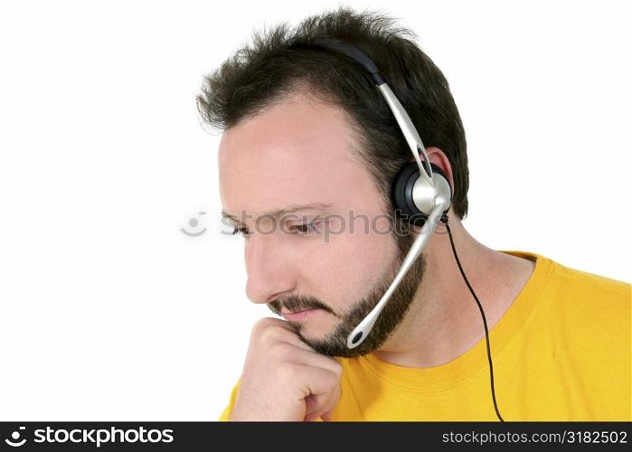 Casual man in yellow shirt listening to headset over white.