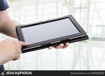 Casual man using touch pad, close up shot on tablet pc, at the office