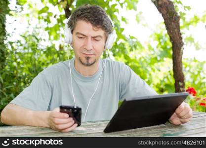 casual man working with a tablet pc and phone, outdoor