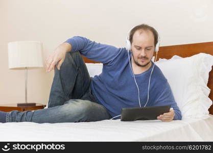 casual man working with a tablet pc in bed