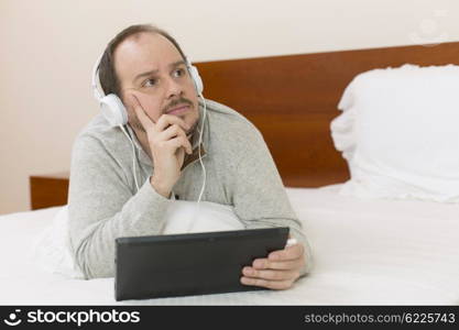 casual man working with a tablet pc in bed